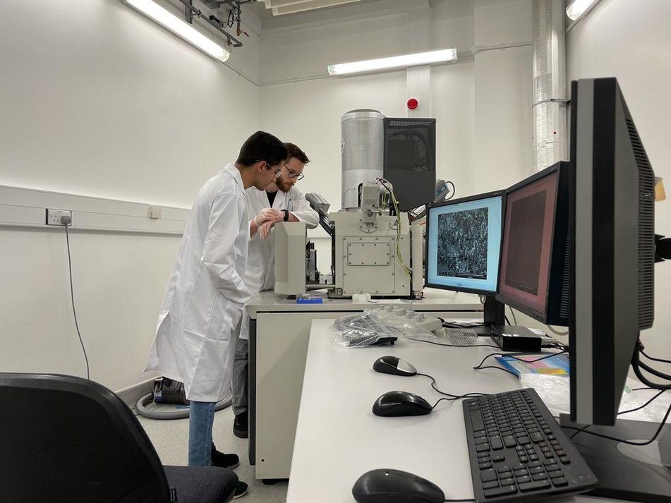 David (ESR 10) at Cambridge University for his secondment. In the picture, Tim (ESR 6) is explaining the SEM equipment.